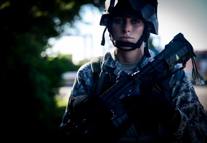 Senior Airman Sandra Welch, 1st Combat Camera Squadron combat photographer, looks on during a simulated patrol on Oct. 4, 2013, at the Joint Base Charleston-Weapons Station, S.C. Airmen from the 1st CTCS trained on how to document outside the wire operations by patrolling through four villages and engaging hostile forces in simulated training. The exercise was geared to familiarize and test the Airmen on their ability to operate outside the wire as combat documentation specialists. (U.S. Air Force photo/Tech. Sgt. Rasheen Douglas)