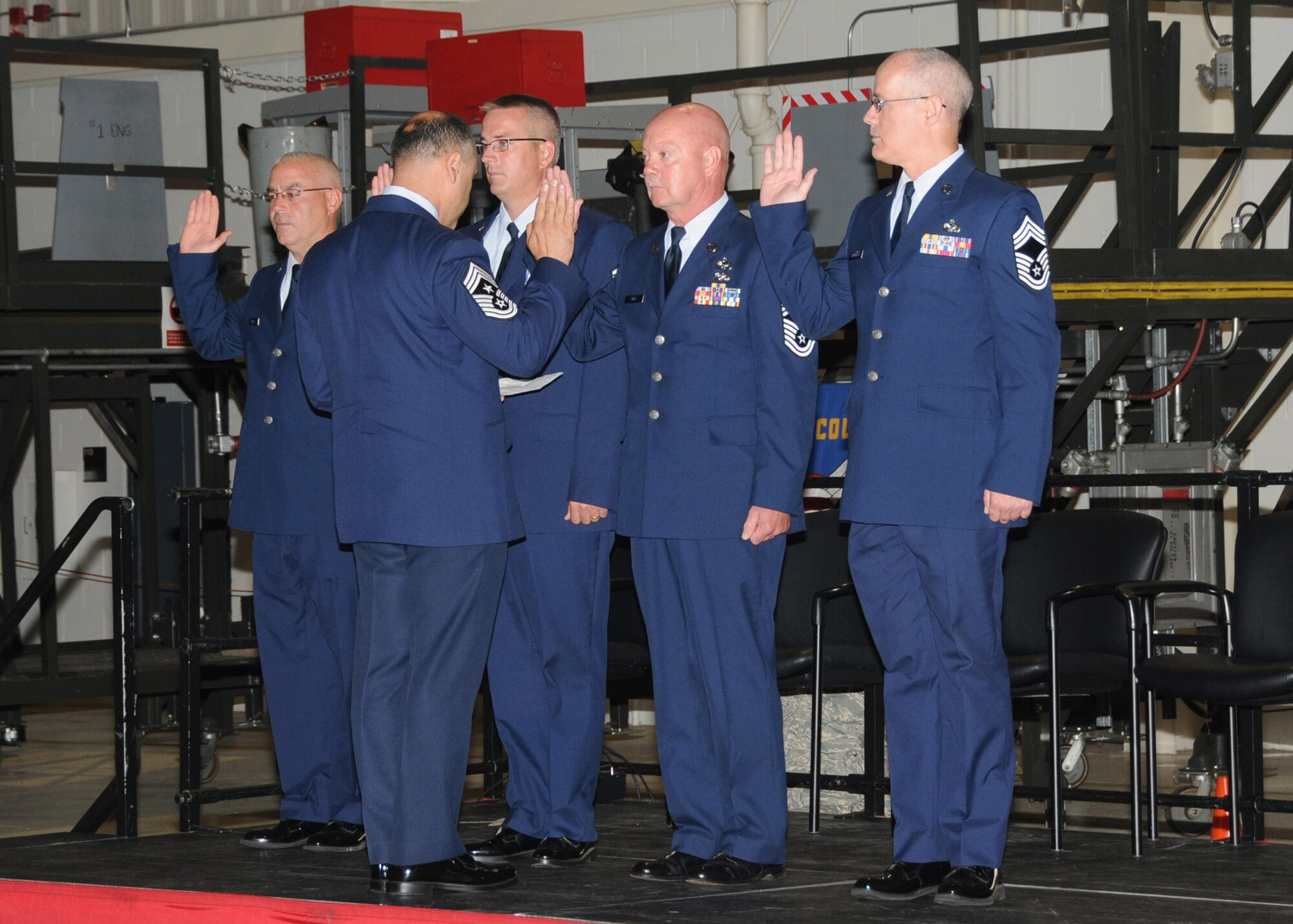 Chief Master Sergeant Jose Baltazar, Command Chief of the 143d Airlift Wing, administers the Chief's Oath to newly promoted Chiefs (L-R) Daniel Mucci, 143d Civil Engineering Squadron, Sean Ballard, 143d Airlift Squadron, Richard Ball, 143d Logistics Readiness Squadron, and Patrick Cavanaugh, 143d Logistics Readiness Squadron during a combined ceremony celebrating the Change of Command of the 143d Mission Support Group, Assumption of Command of the 143d Communications Flight, and the promotion ceremony for the four Chiefs. National Guard Photo by Technical Sergeant Jason Long