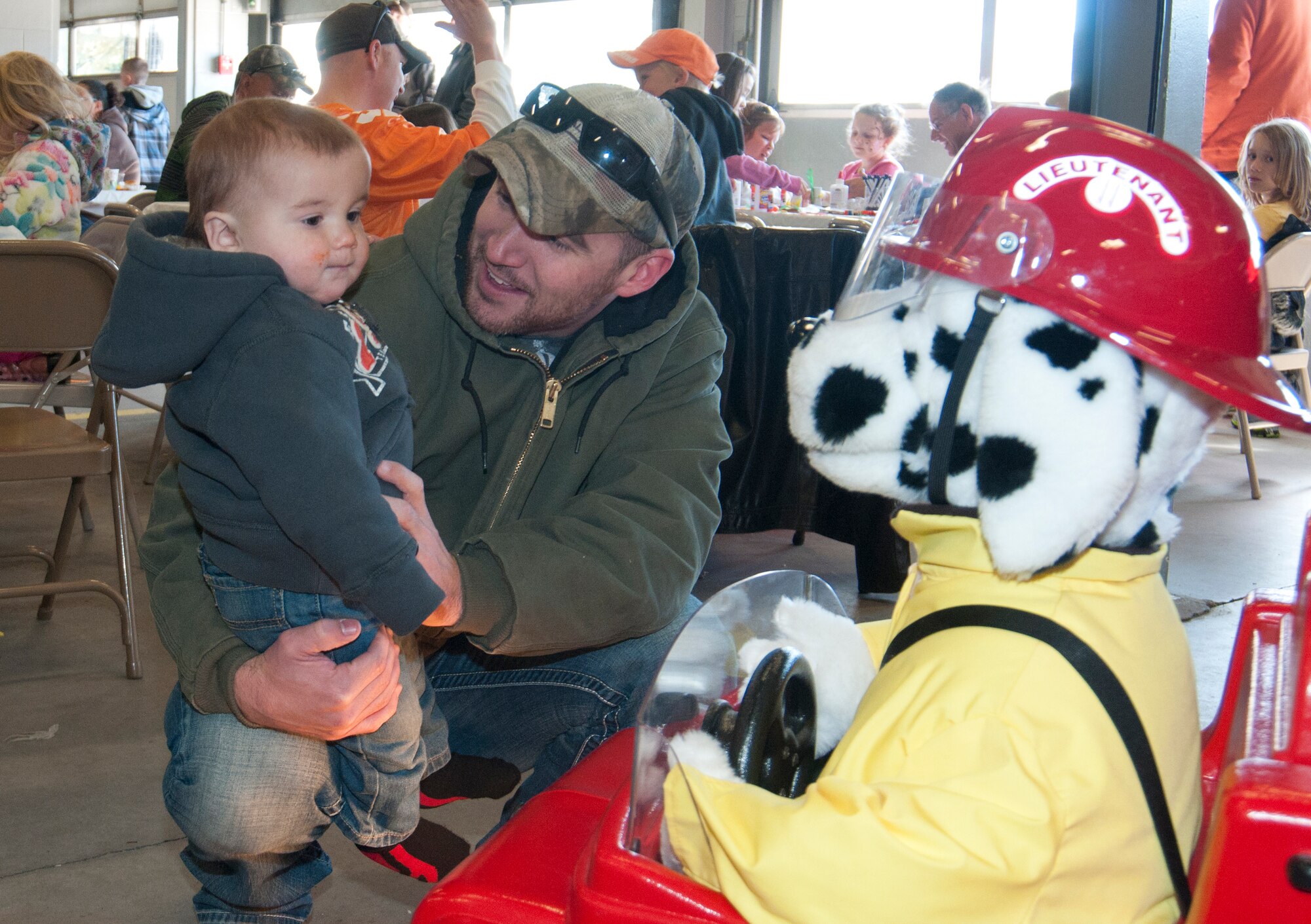 Army Spc. Brody Schnell, Wyoming National Guard Detachment 53 aviation operations specialist, introduces his son, Kasey, to Sparky the Fire Dog during an open house in F.E. Warren Fire Station 2 Oct. 5, 2013. Firefighters helped provide fire prevention education to guests who were treated to lunch and a choice of pumpkins for kids to carve later for Halloween, both provided by Balfour Beatty Communities. (U.S. Air Force photo by Airman 1st Class Jason Wiese)