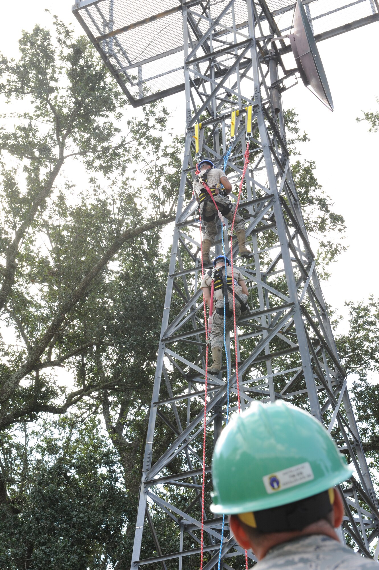 Brig. Gen. Patrick Higby, 81st Training Wing commander, watches two 85th Engineering Installation Squadron members climb a training tower for a demonstration of a tower rescue maneuver during the 85th EIS open house Oct. 3, 2013, Keesler Air Force Base, Miss. The open house was held to educate leadership on the unique services and day-to-day operations of the Air Force’s only active duty engineering installation squadron. (U.S. Air Force photo by Airman 1st Class Stephan Coleman)