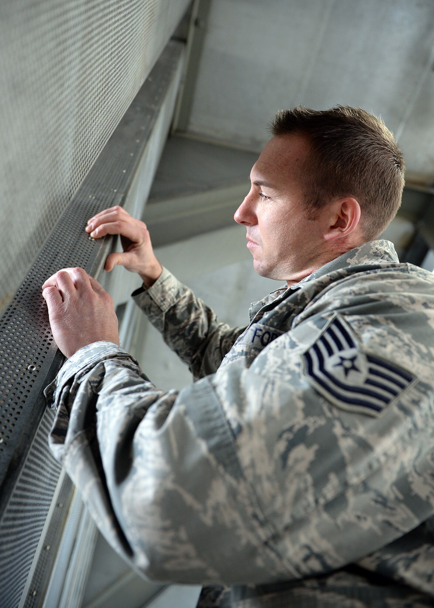 Tech. Sgt. Joshua Baker, 354th Maintenance Squadron propulsion flight test cell chief, inspects rivets on the walls of the “Hush House” after an engine test Oct. 3, 2013, Eielson Air Force Base, Alaska. The thrust of the engine being tested produces so much wind and turbulence that rivets have to be checked regularly to ensure the building doesn’t come apart. (U.S. Air Force photo by Senior Airman Shawn Nickel/Released)