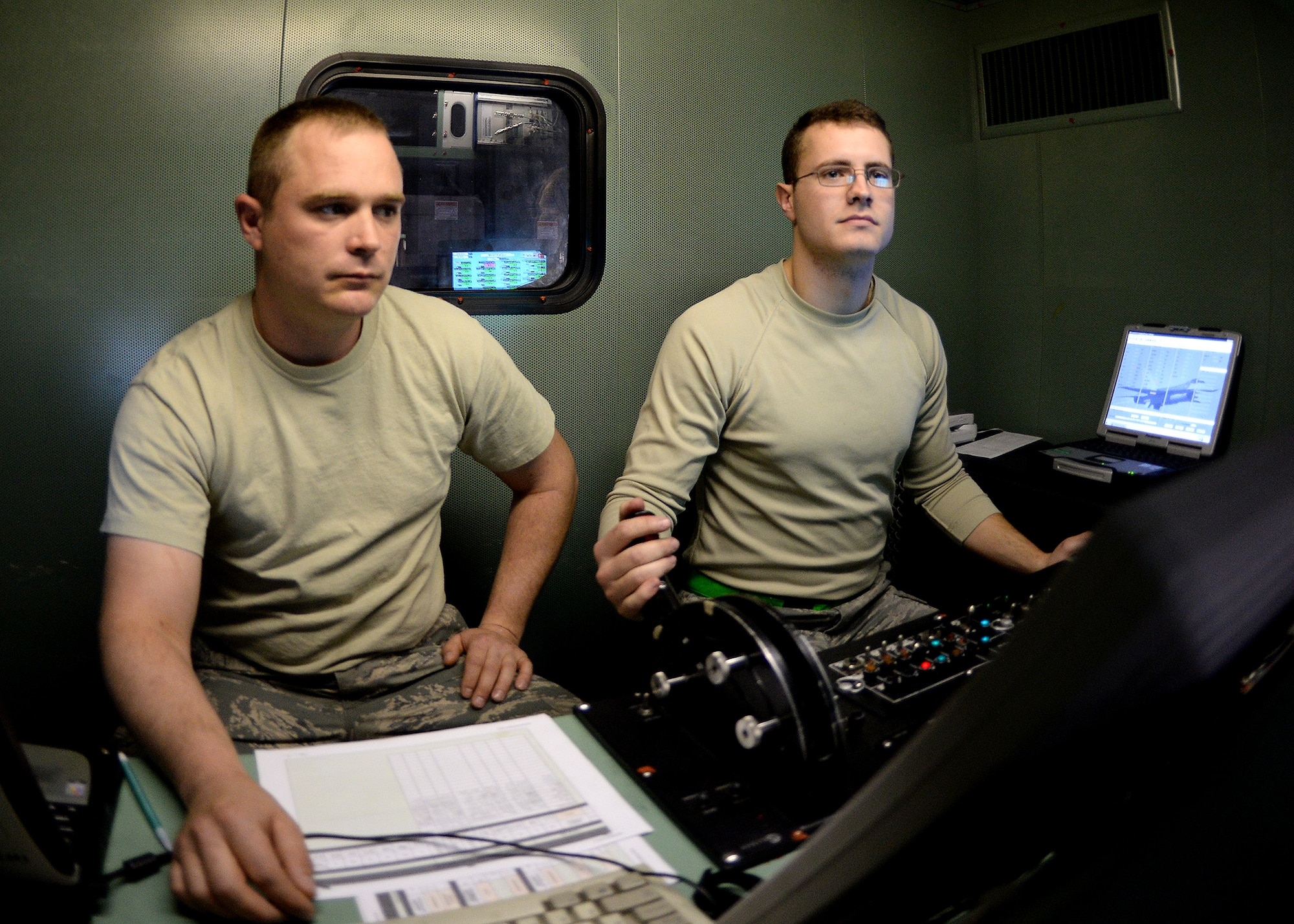 Senior Airman Alec Dyer, 354th Maintenance Squadron aerospace propulsion journeyman, pushes the throttle forward to accelerate an engine from an F-16 Fighting Falcon while Staff Sgt. Christopher Brock, 354th MXS aerospace propulsion craftsman, collects data during a test at the “Hush House” Oct. 3, 2013, Eielson Air Force Base, Alaska. From the beginning of an engine rebuild to the end can take days to months depending on the availability of parts and the condition of the General Electric F-110-100 engine. (U.S. Air Force photo by Senior Airman Shawn Nickel/Released)
