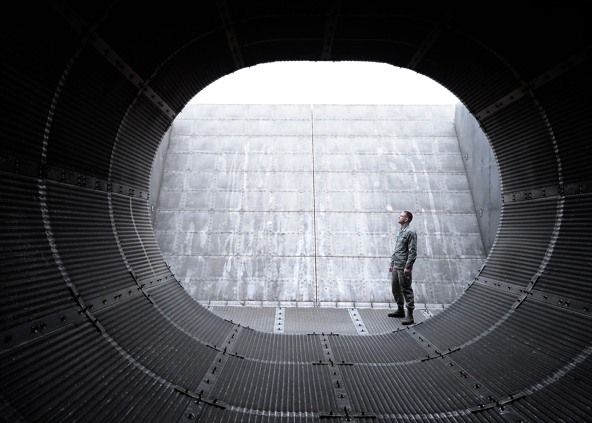 Staff Sgt. Daniel Kaufman, 354th Maintenance Squadron propulsion flight dock chief, checks the clearance of the exhaust tube at the “Hush House” prior to an engine test Oct. 3, 2013, Eielson Air Force Base, Alaska. The specially designed tube dampens the sound using corrugated metal panels filled with a material resembling steel wool. (U.S. Air Force photo by Senior Airman Shawn Nickel/Released)