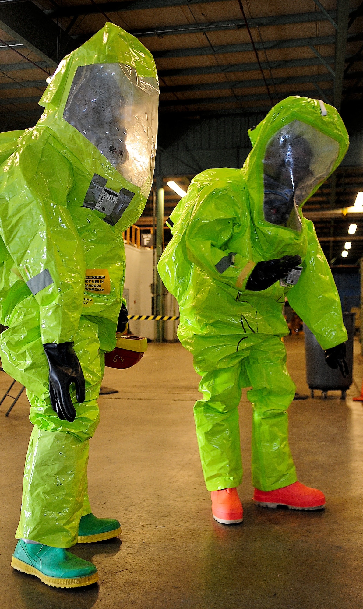 Senior Airman Joseph Davis, 436th Civil Engineer Squadron emergency management technician, and Airman 1st Class Alexander Delfs, 436th Aero-Medical Squadron bioenvironmental engineering technician, inspect a simulated HAZMAT scene during a medical readiness exercise Oct. 2, 2013, at Dover Air Force Base, Del. They inspected the area wearing Level-A suits to protect themselves from any vapors or radiation. (U.S. Air Force photo/Airman 1st Class Ashlin Federick)
