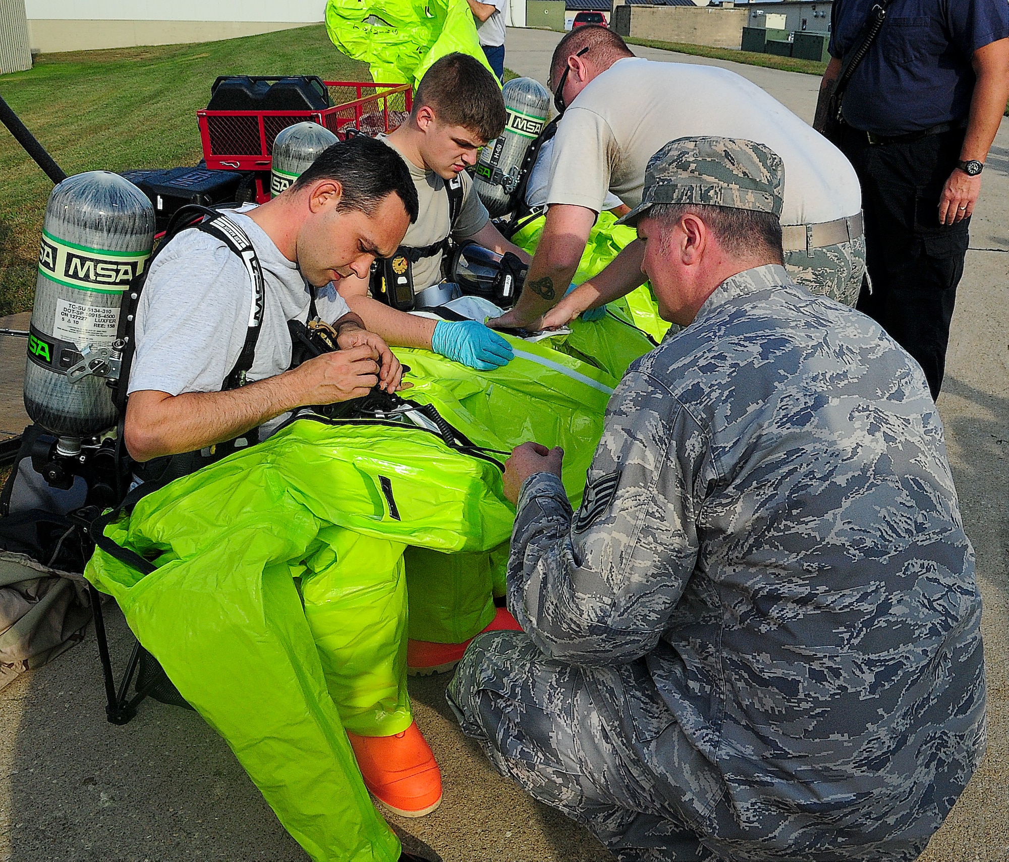 Senior Airman Joseph Davis, 436th Civil Engineer Squadron emergency management technician, and Airman 1st Class Alexander Delfs, 436th Aero-Medical Squadron bioenvironmental engineering technician, gear up in their Level-A suits during a medical readiness exercise Oct. 2, 2013, on Dover Air Force Base, Del. The team surveyed the area for vapors and radiation. (U.S. Air Force photo/Airman 1st Class Ashlin Federick)