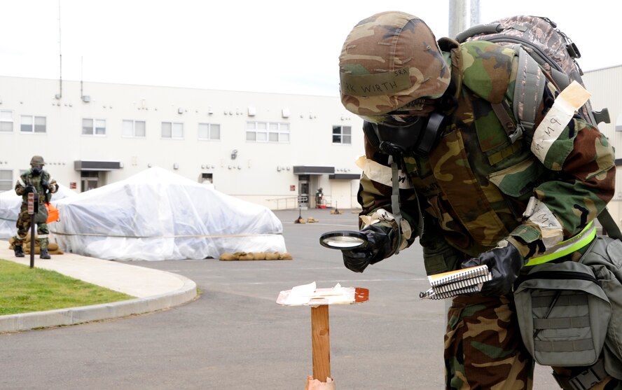 Senior Airman Mark Wirth, 35th Civil Engineer Squadron structures apprentice, checks simulated M8 Chemical Agent Detection Paper for contamination during an Operational Readiness Exercise at Misawa Air Base, Japan, Oct. 8, 2013. An ORE is used to simulate a contingency environment and see how Airmen react in a stressful environment. (U.S. Air Force photo by Airman 1st Class Kaleb Snay)