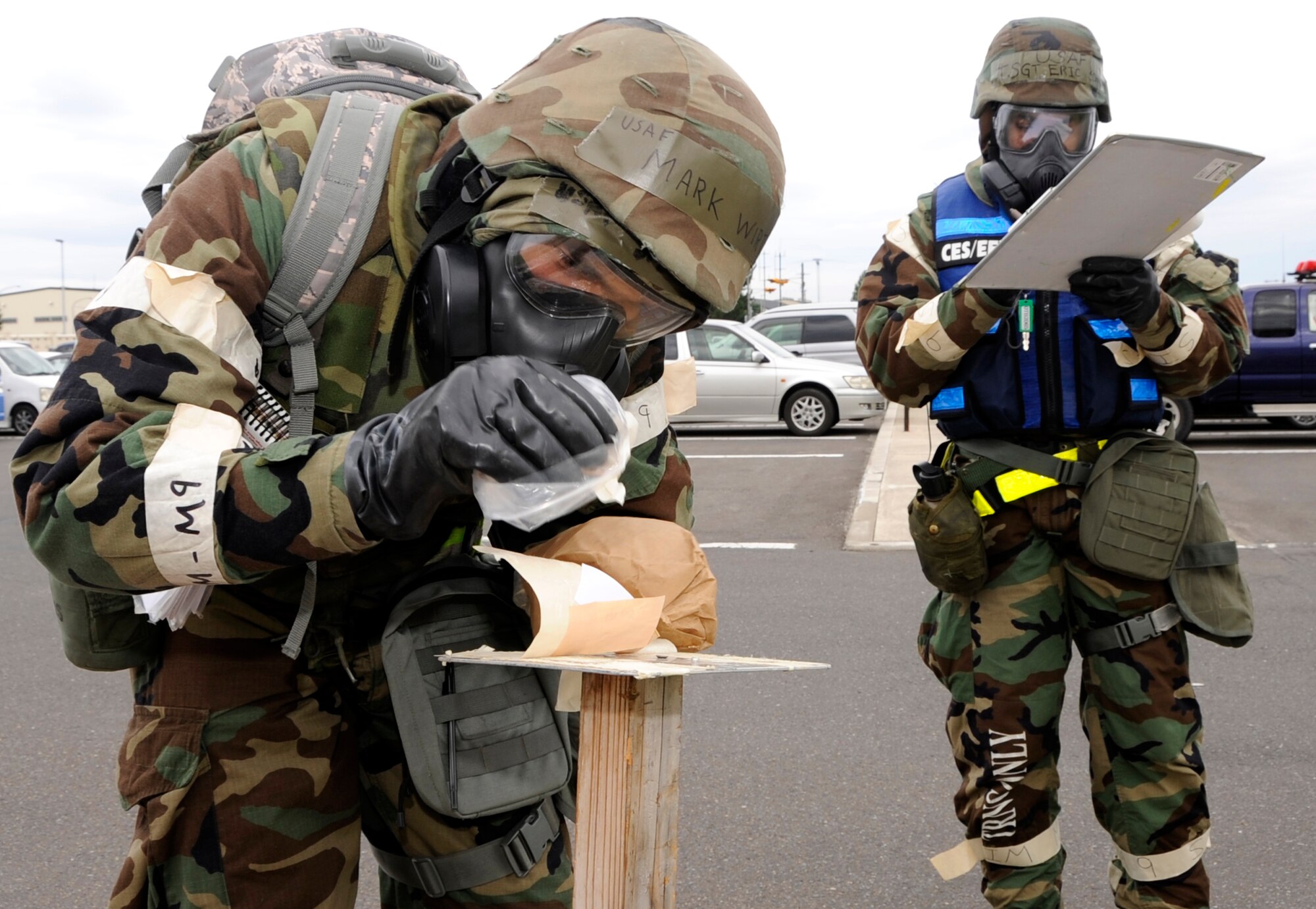 Senior Airman Mark Wirth, 35th Civil Engineer Squadron structures apprentice, left, removes simulated M8 Chemical Agent Detection Paper while being evaluated by Tech. Sgt. Eric Schmidt, 35th Inspector General Wing Inspector Team evaluator, during an Operational Readiness Exercise at Misawa Air Base, Japan, Oct. 8, 2013. While performing a Post Attack Reconnaissance sweep, Wirth noticed the paper indicated a nerve agent was present. (U.S. Air Force photo by Airman 1st Class Kaleb Snay)