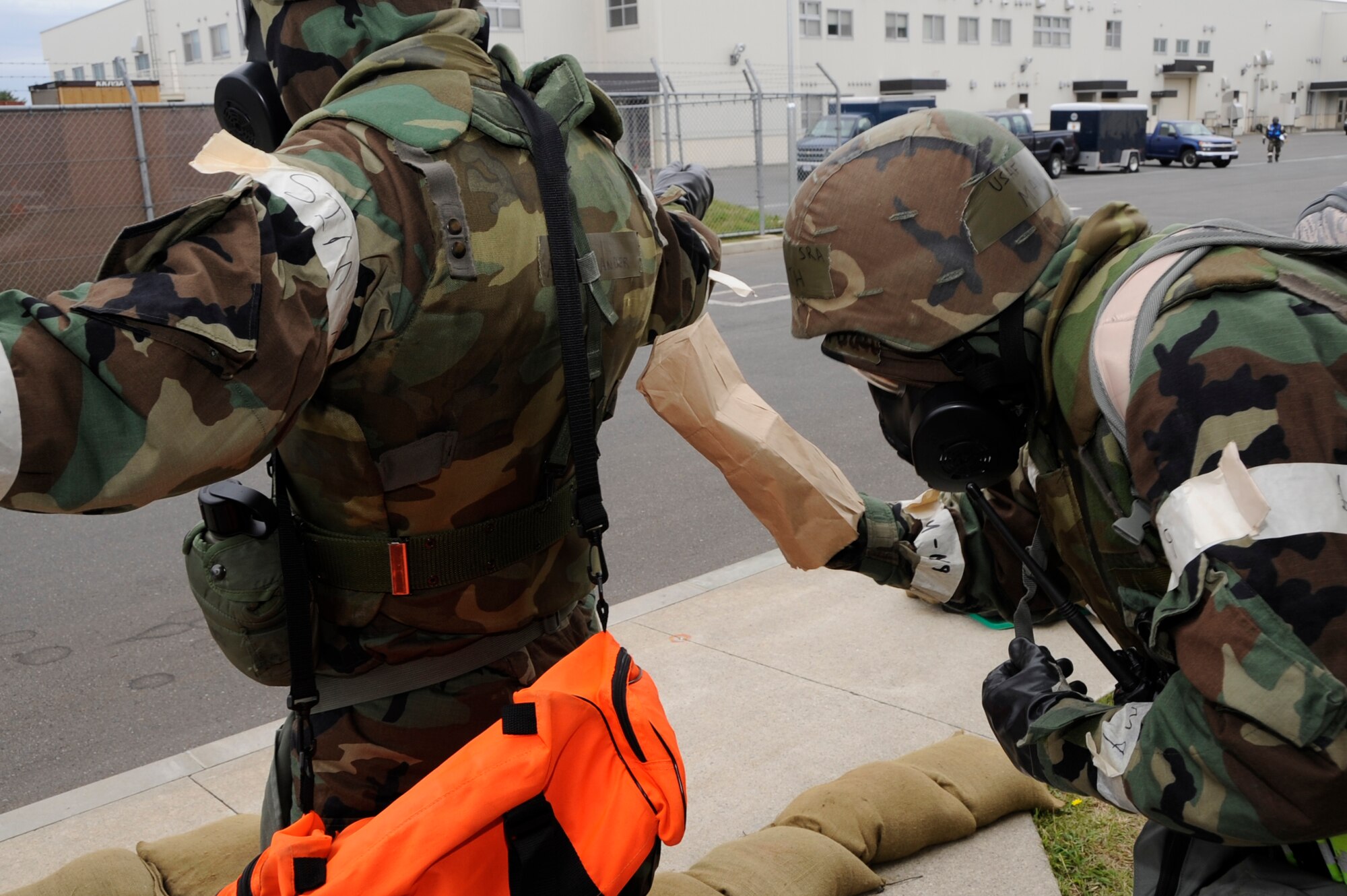 Senior Airman Mark Wirth, 35th Civil Engineer Squadron structures apprentice, right, simulates decontaminating Airman 1st Class Joshua Anderson, 35 CES heating ventilation and air conditioning apprentice, during an Operational Readiness Exercise at Misawa Air Base, Japan, Oct. 8, 2013. After the Post Attack Reconnaissance sweep, the Airmen must decontaminate each other and their gear before they go inside. (U.S. Air Force photo by Airman 1st Class Kaleb Snay)