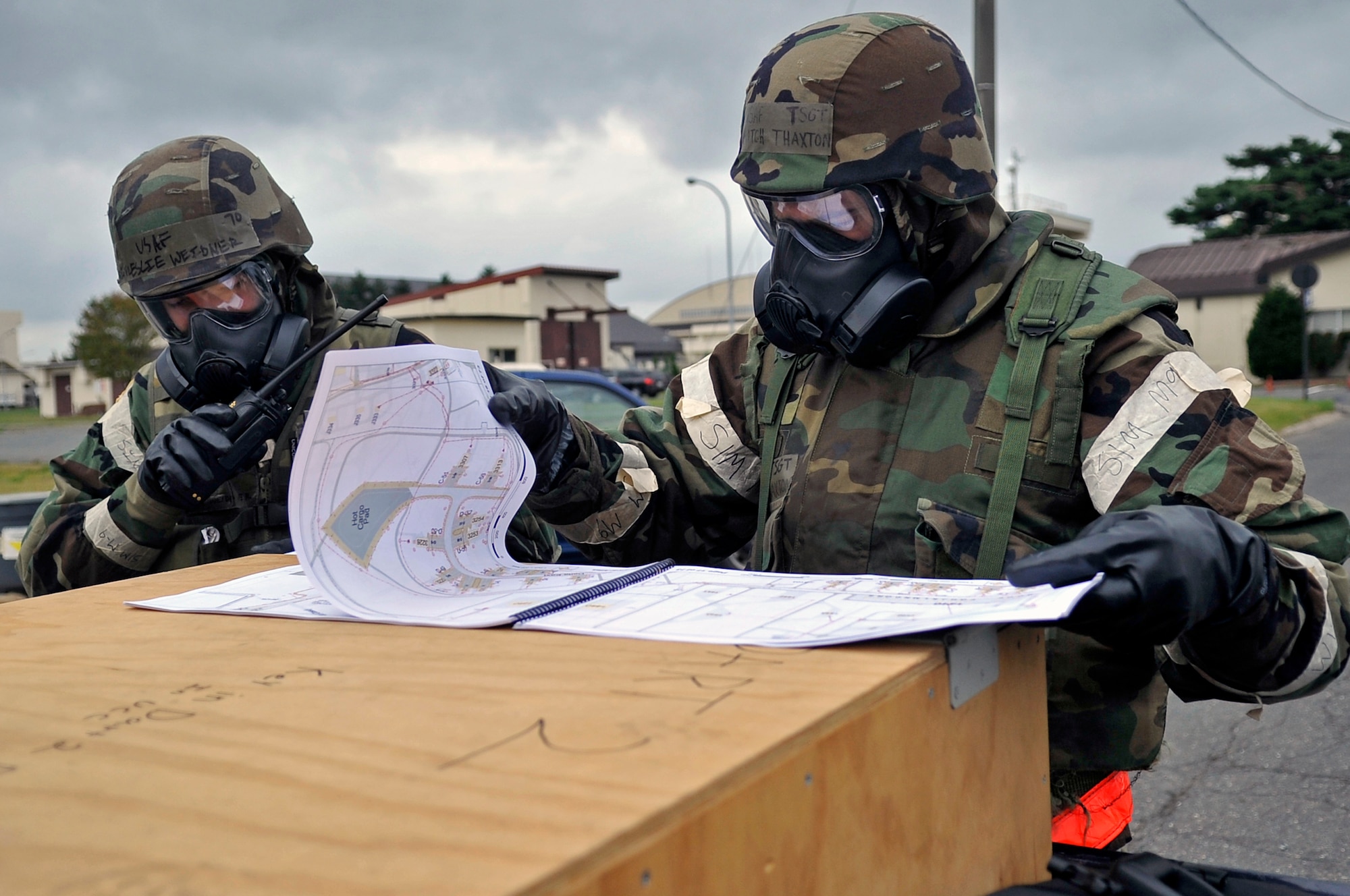 U.S. Air Force Tech. Sgt. Mitchell Thaxton, 35th Civil Engineer Squadron Damage Assessment Response Team member, reviews a base map while Staff Sgt. Leslie Weidner radios in an exercise inject at Misawa Air Base, Japan. Airmen of the 35th Fighter Wing were tested on their ability to operate in a simulated combat environment. (U.S. Air Force photo by Airman 1st Class Zachary Kee) 