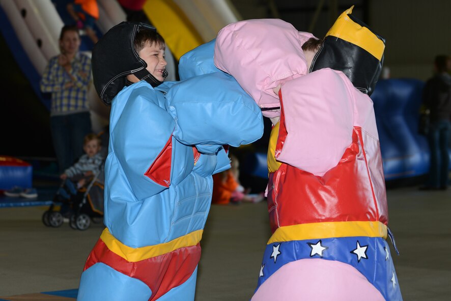Angelo Clemente, 7, son of U.S. Air Force Tech. Sgt. Eduardo Clemente, 352nd Special Operations Support Squadron NCO in charge of medical training, wrestles during the Day for Kids event at Royal Air Force Lakenheath, England, Sept. 28, 2013. The Day for Kids was an opportunity for RAF Lakenheath, RAF Mildenhall and RAF Feltwell children to celebrate being a kid and provide parents with the opportunity to chat with experts regarding health or developmental concerns. (U.S. Air Force photo by Airman 1st Class Trevor T. McBride/Released) 
