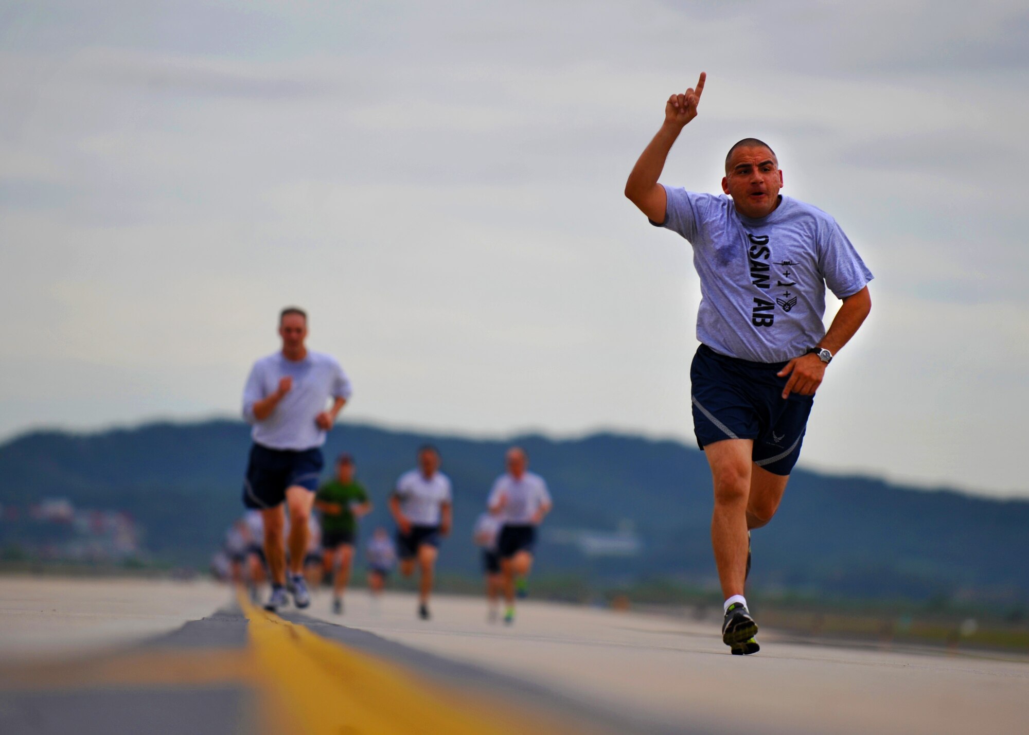 A participant in the 5.1K Warrior Challenge run races toward the finish line at Osan Air Base, Republic of Korea, Oct. 7, 2013. Team Osan members were given the opportunity to participate in the 5.1K run or the Crossfit Runway Challenge as part of the Osan Warrior Challenge, before a base-wide formation run on the flight line. (U.S. Air Force photo/Senior Airman Siuta B. Ika)