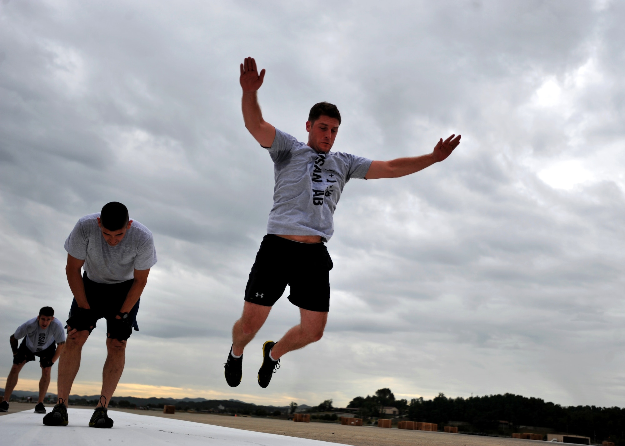 Staff Sgt. Travis Hirshlor, 694th Intelligence Support Squadron critical communications technician, broad jumps after performing a burpee during the Runway Fitness Challenge on the flight line at Osan Air Base, Republic of Korea, Oct. 7, 2013. The burpee broad jumps were the last exercise of the Runway Fitness Challenge, which was part of the Osan Warrior Challenge. (U.S. Air Force photo/Senior Airman Siuta B. Ika)