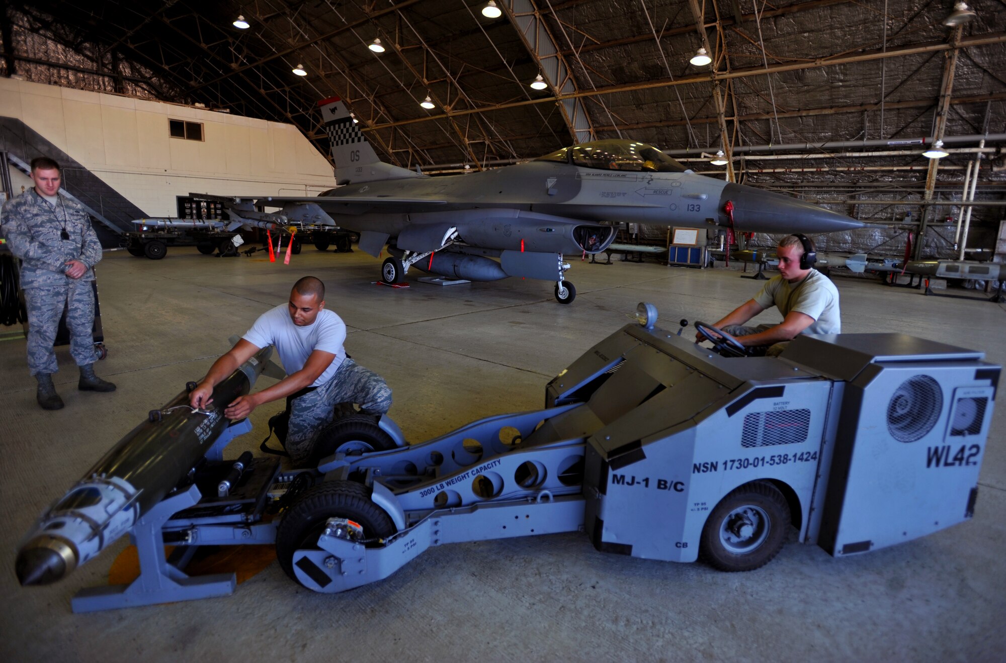 Staff Sgt. Ryan Garrett, 36th Aircraft Maintenance Unit weapons load crew member, prepares a munition to be picked up and loaded onto an F-16 Fighting Falcon during a quarterly weapons load crew competition at Osan Air Base, Republic of Korea, Oct. 4, 2013. During a weapons load crew competition, each member has a set of tasks to carry out and must work on a team of three or four, depending on the aircraft they are assigned to. (U.S. Air Force photo/Senior Airman Siuta B. Ika)