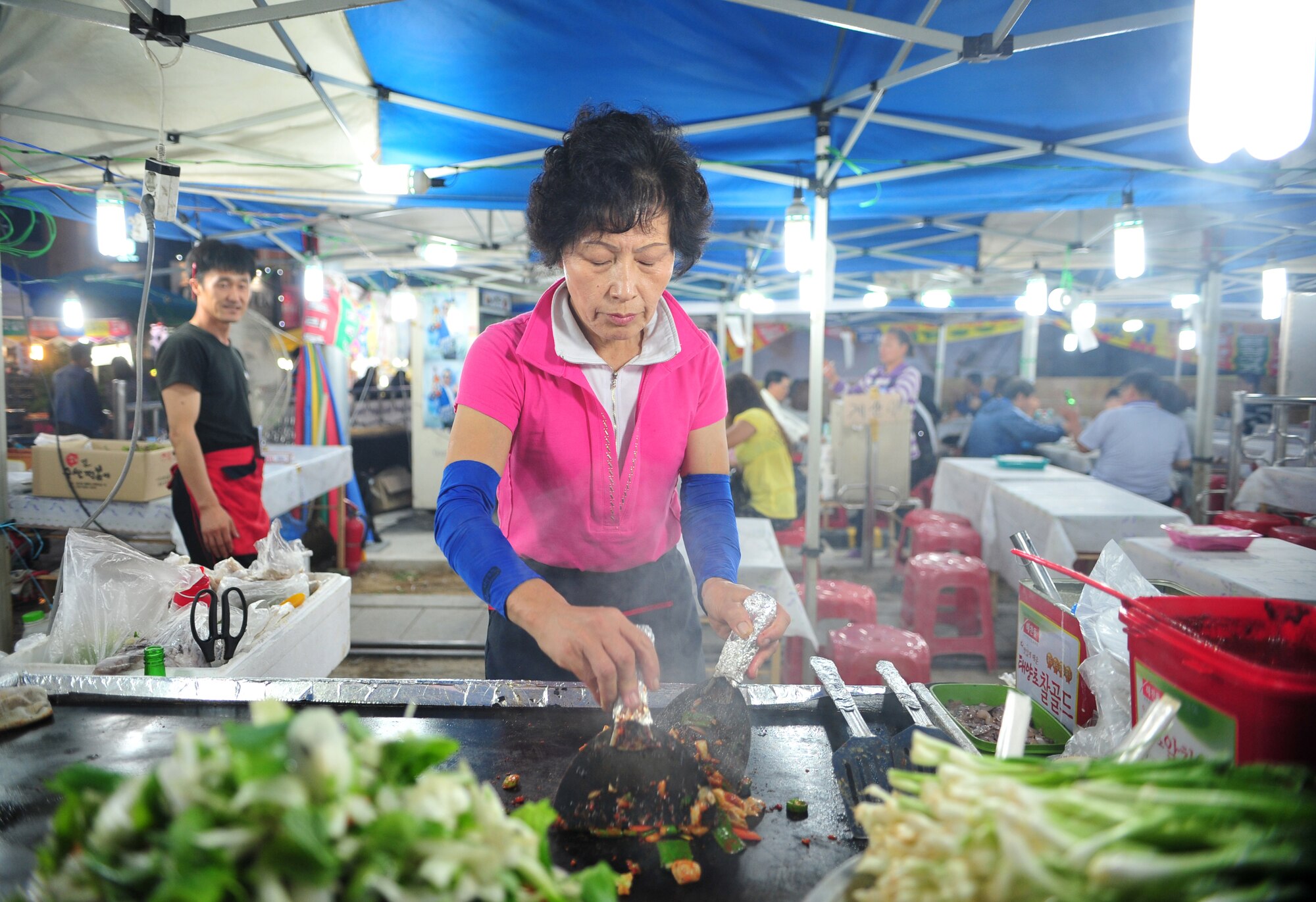 A vendor prepares a fresh dish for her booth at the 10th Annual Korean-American Friendship Festival in the Songtan Entertainment District, Republic of Korea, Oct. 6, 2013. The celebration lasted for two days and was an interactive way for Koreans and Americans to experience each other’s culture and build strong relationships between their communities. (U.S. Air Force photo/Airman 1st Class Ashley J. Thum)