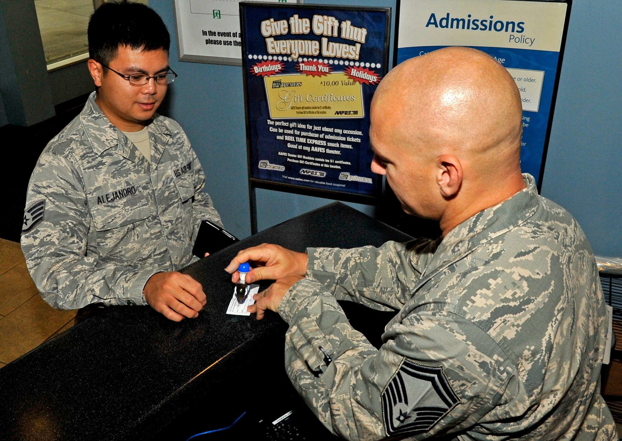 U.S. Air Force Senior Master Sgt. Jason Schmitz, 35th Force Support Squadron career assistance advisor, stamps a transition area accountability card for Staff Sgt. Matthew Alejandro, 35th Communications Squadron project manager, during phase two of an Operational Readiness Exercise at Misawa Air Base, Japan, Oct. 8, 2013. Although Airmen work at various locations around the base during an ORE, everyone starts their day at the TA. The TA is used to update Airmen on new mission oriented protective posture levels or any safety measures that have been implemented while they were off duty. (U.S. Air Force photo by Airman 1st Class Zachary Kee)