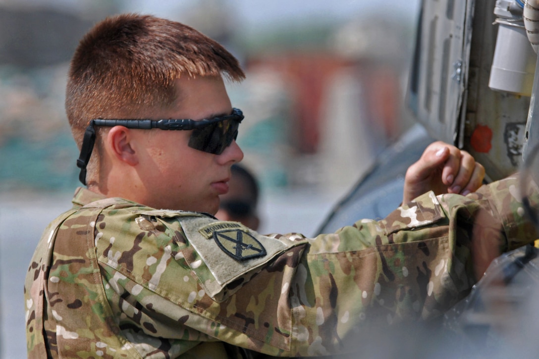 U.S. Army Spc. Benjamin Katzenberger performs maintenance on an OH-58D Kiowa Warrior helicopter on Forward Operating Base Fenty in Afghanistan's Nangarhar province, Oct. 3, 2013. Katzenberger, a helicopter repairer, is assigned to 1st Battalion Attack, 10th Combat Aviation Brigade.