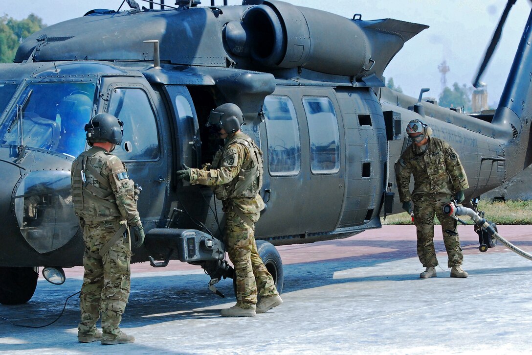 U.S. Army Spc. Kaleb Turner, left, observes as a petroleum supply specialist prepares to refuel his UH-60M Blackhawk helicopter on Forward Operating Base Fenty in Afghanistan's Nangarhar province, Oct. 3, 2013. Turner, a crew chief, is assigned to Company A, 2nd Battalion Assault, 10th Combat Aviation Brigade.