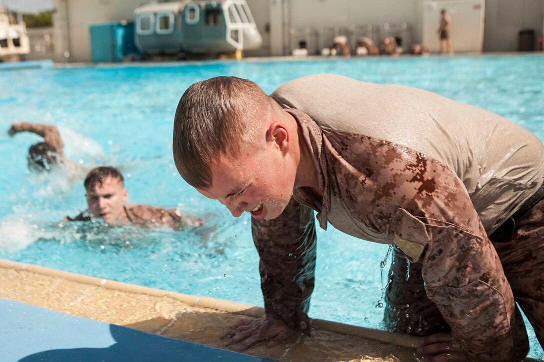 Marines with Company E., Battalion Landing Team 2nd Battalion, 4th Marines, 31st Marine Expeditionary Unit, climb out of a pool during a combat endurance course here, Oct. 9. The endurance course is a two-day event consisting of various exercises at stations around Camp Hansen, including: performing mask drills in the gas chamber, digging a fighting hole, calling a “nine-line” casualty evacuation,  swimming laps in a pool and assembling different weapon systems. The purpose of the course is to keep tactical skills fresh in a garrison environment. The 31st MEU is the Marine Corps’ force in readiness in the Asia-Pacific region and the only continuously forward deployed MEU.