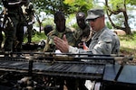 Army Sgt. 1st Class Jonathan Pearson, with the 166th regiment, Regional Training Institute, works through an engineering problem with combat engineers from the Ghanaian army using a scale model of a bridge at the Ghanaian army's Coker-Appiah Engineer Training School in Accra, Ghana, Thursday, May 17, 2012. Pearson was working with the Ghanaian engineers as part of a week-long engineer course through the State Partnership Program, which partners National Guard units with 65 countries throughout he world as a way to foster greater relationships between nations.