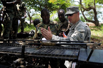 Army Sgt. 1st Class Jonathan Pearson, with the 166th regiment, Regional Training Institute, works through an engineering problem with combat engineers from the Ghanaian army using a scale model of a bridge at the Ghanaian army's Coker-Appiah Engineer Training School in Accra, Ghana, Thursday, May 17, 2012. Pearson was working with the Ghanaian engineers as part of a week-long engineer course through the State Partnership Program, which partners National Guard units with 65 countries throughout he world as a way to foster greater relationships between nations.