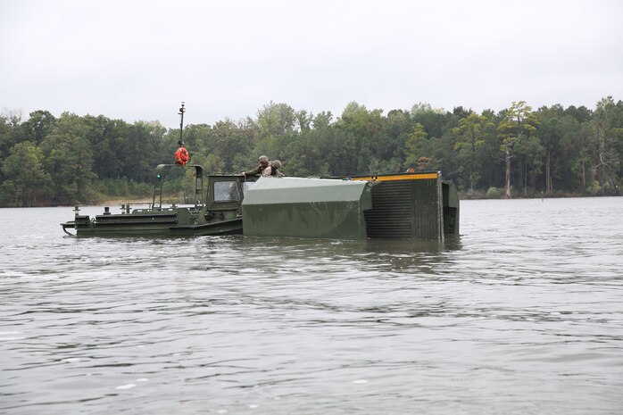 Marines with Bridge Company, 8th Engineer Support Battalion, 2nd Marine Logistics Group use a MK III Bridge Erection Boat to maintain control of an Improved Ribbon Bridge section at Engineer Point aboard Camp Lejeune, N.C., Oct. 8, 2013. Bridge Co. received support from 2nd Tank Battalion, 2nd Marine Division, allowing them to continue training and maintain mission readiness. (U.S. Marine Corps photo by Lance Cpl. Shawn Valosin)