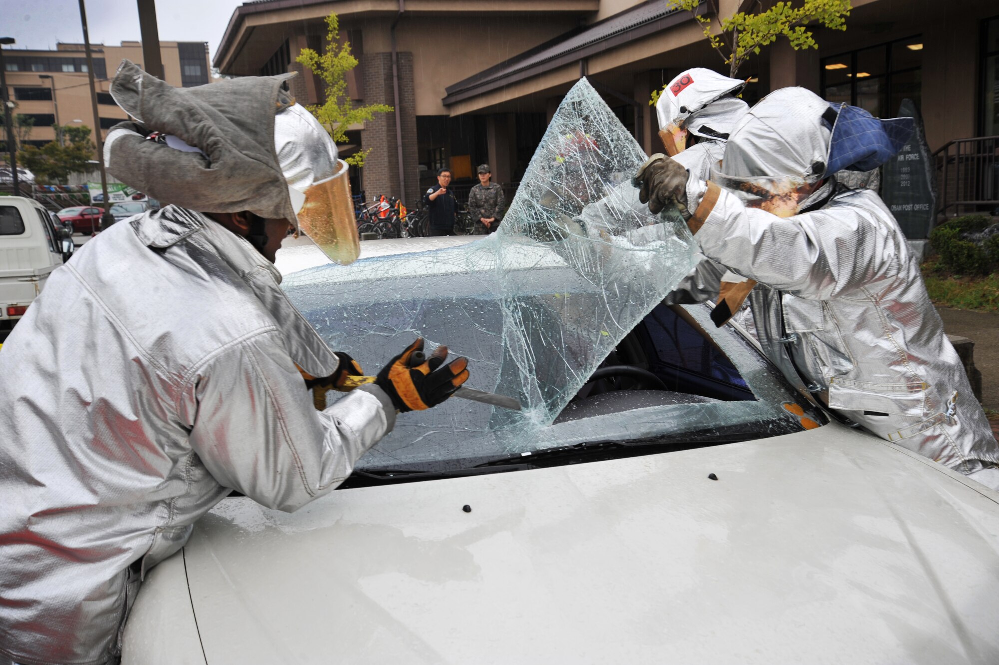 Senior Airmen Emmanuel Davis, left, and Robert McCallon, 51st Civil Engineer Squadron fire and emergency services flight firefighters, tear off the windshield of a vehicle during an extrication demonstration at Osan Air Base, Republic of Korea, Oct. 8, 2013. The demonstration was held to kick off fire prevention week, which has been observed annually since 1922. (U.S. Air Force photo/Staff Sgt. Emerson Nuñez)