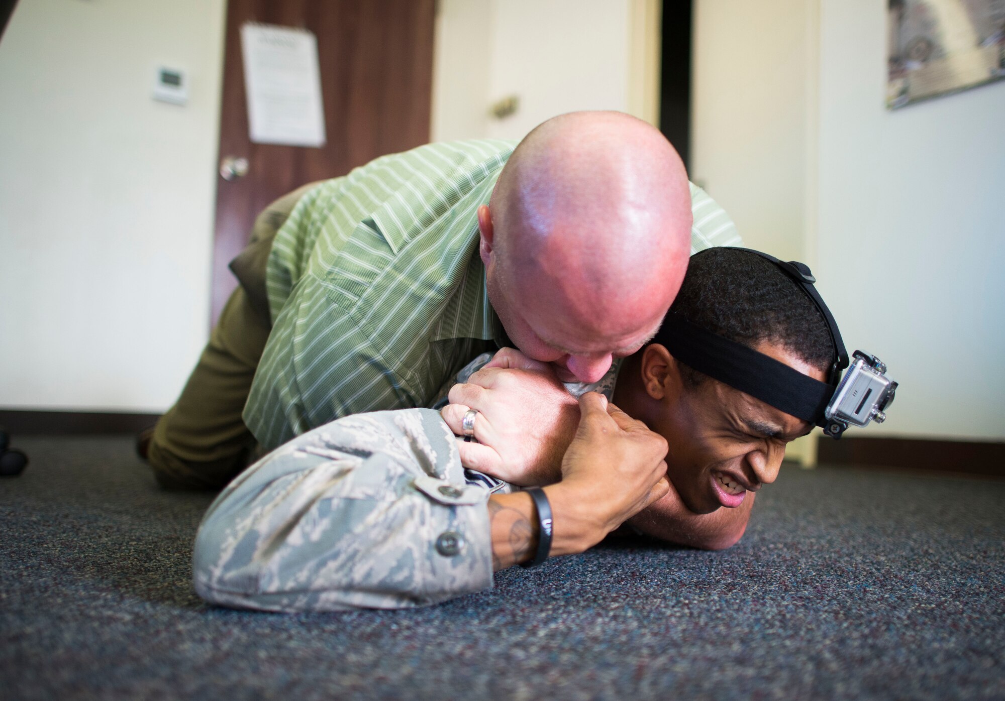 Senior Airman Lamon Irvin, 374th Logistics Readiness Squadron simulated active shooter, fights with a civilian during an active shooter scenario part of readiness week at Yokota Air Base, Japan, Oct. 10, 2013. The scenario allowed security forces personnel to hone their skills during a contingency. (U.S. Air Force photo by Staff Sgt. Chad C. Strohmeyer/Released)