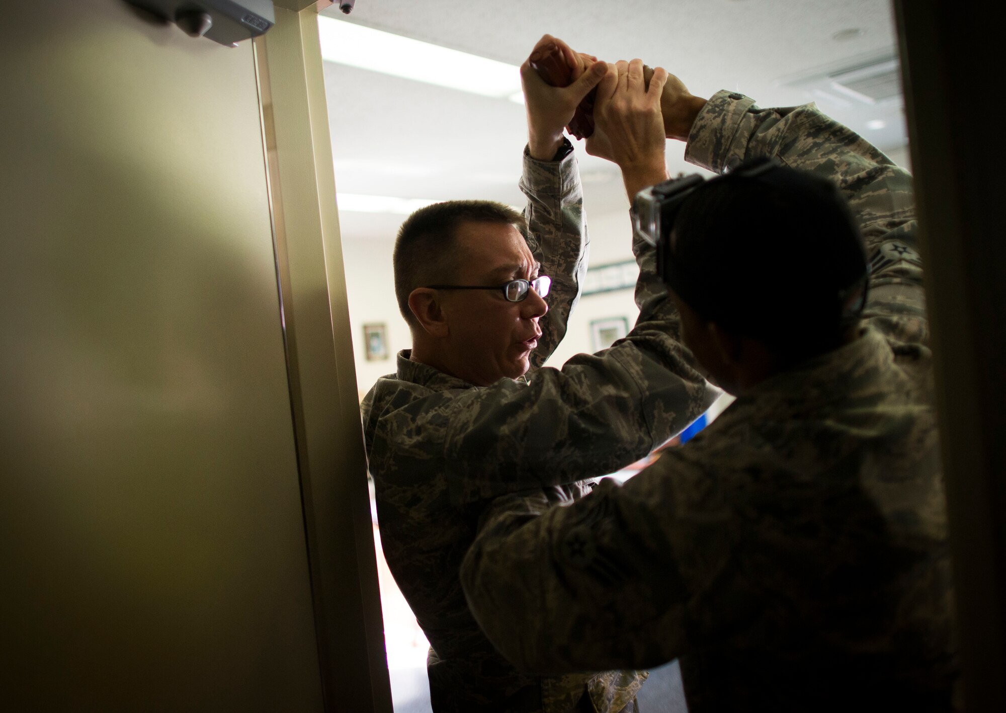 Maj. Paul Barthel, 374th Logistics Readiness Squadron commander, fights with a simulated shooter during an active shooter scenario part of readiness week at Yokota Air Base, Japan, Oct. 10, 2013. The scenario allowed security forces personnel to hone their skills during a contingency. (U.S. Air Force photo by Staff Sgt. Chad C. Strohmeyer/Released)
