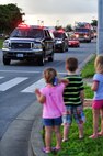 Children watch as members from the 18th Civil Engineer Squadron drive down a street during the Fire Prevention Week parade on Kadena Air Base, Japan, Oct. 09, 2013. The Kadena fire department led the parade through base housing while throwing candy to crowds of children and members of Team Kadena as part of a week-long effort to promote fire safety and prevention. (U.S. Air Force photo by Staff Sgt. Amber E. N. Jacobs)