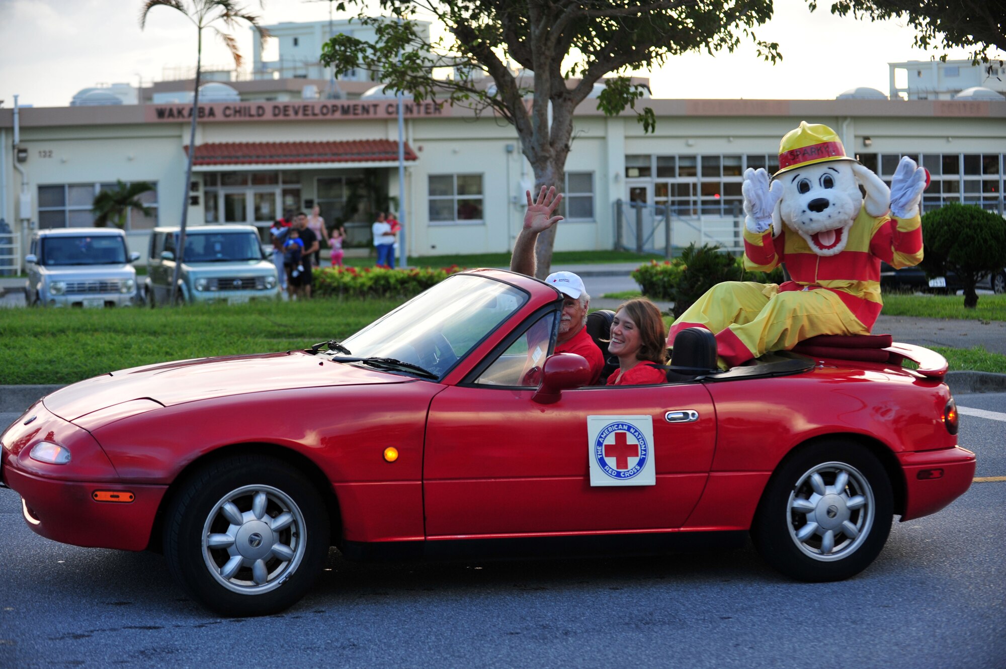 Sparky, the fire dog, waves to children during the Fire Prevention Week parade on Kadena Air Base, Japan, Oct. 09, 2013. The parade was part of a week-long effort to promote fire safety and prevention to members of Team Kadena. (U.S. Air Force photo by Staff Sgt. Amber E. N. Jacobs)