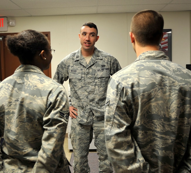 1st Lt. Joe Regan, 2nd Comptroller Squadron Financial Management Analysis flight commander speaks to Airmen 1st Class Jessica Bicy and Michael Pudvah, Financial Management flight customer service representatives, on Barksdale Air Force Base, La. Sept. 30, 2013. Part of military service is showing respect and military bearing. One way Airmen can demonstrate this is by remembering military customs and courtesies as they stand at parade rest while an officer is talking to them. (U.S. Air Force Photo/Airman 1st Class Benjamin Raughton)