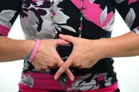 Jessica Newbury, forms her fingers in the shape of the Breast Cancer Awareness symbol Oct. 9, 2013, at Joint Base Charleston – Air Base, S.C. Newbury joined the United States Navy in 2003 and served for eight years as a machinist mate before her medical retirement. Newbury is a breast cancer survivor and continues to be an inspiration for those that know her and her story.   (U.S. Air Force photo/ Airman 1st Class Chacarra Neal)
