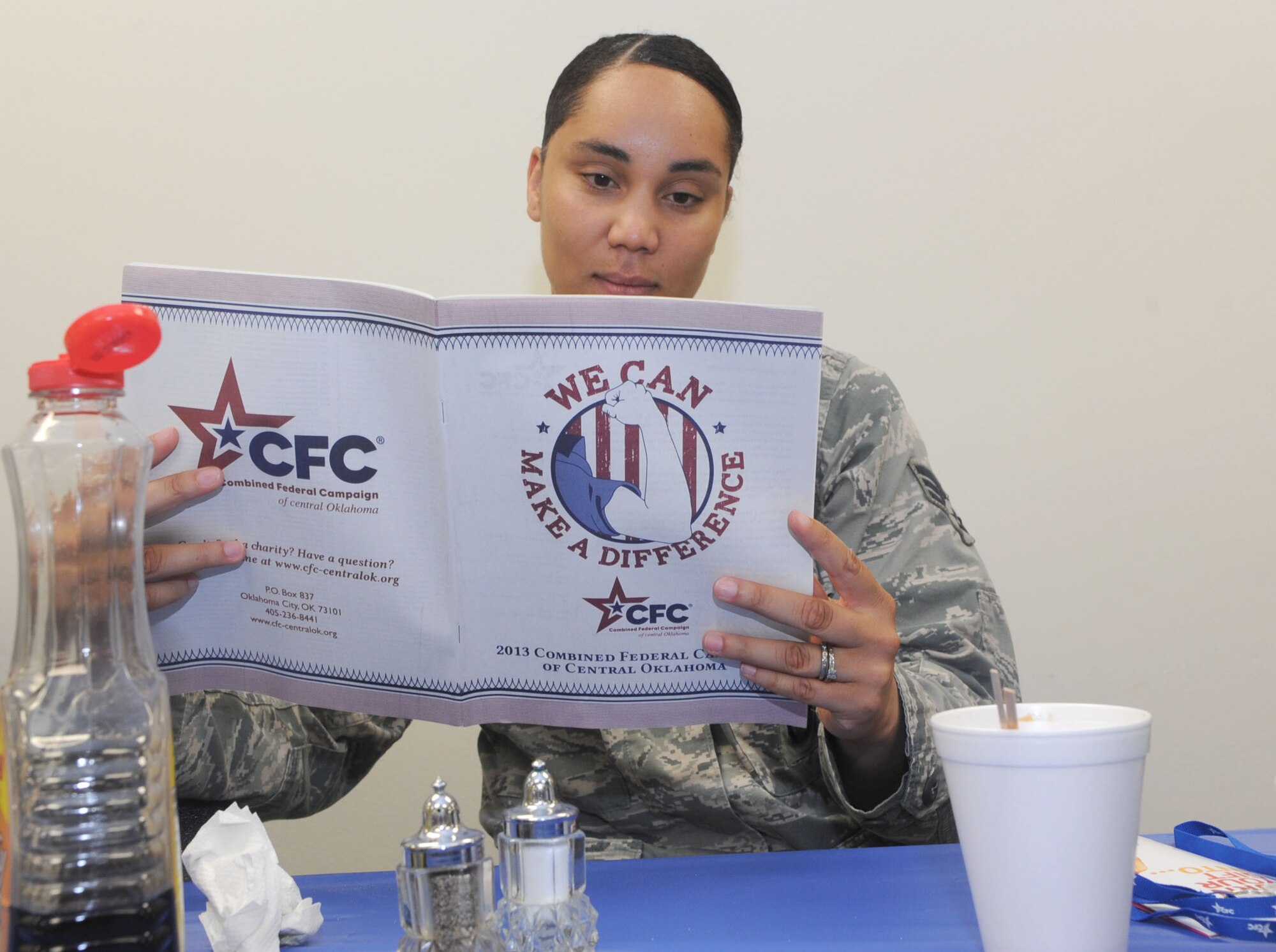 Senior Airman Tynisia Hains, a 71st Security Forces Squadron combat arms instructor, reads through a Combined Federal Campaign catalogue during the CFC-kick off breakfast Oct. 3 in the Community Chapel Activity Center at Vance Air Force Base, Okla. The CFC kicked off Sept. 30 and runs until Nov. 8. (U.S. Air Force photo/ Senior Airman Frank Casciotta)