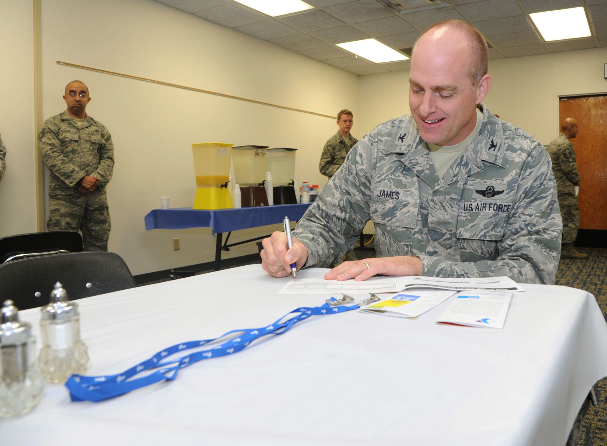 Col. Darren James, the 71st Flying Training Wing commander, signs his Combined Federal Campaign donation form during the CFC breakfast kick off Oct. 3 in the Community Chapel Activity Center at Vance Air Force Base, Okla. More than 180 Airmen attended the 7 a.m. breakfast for free food and the opportunity to donate to charity organizations of their choice. (U.S. Air Force photo/ Senior Airman Frank Casciotta)