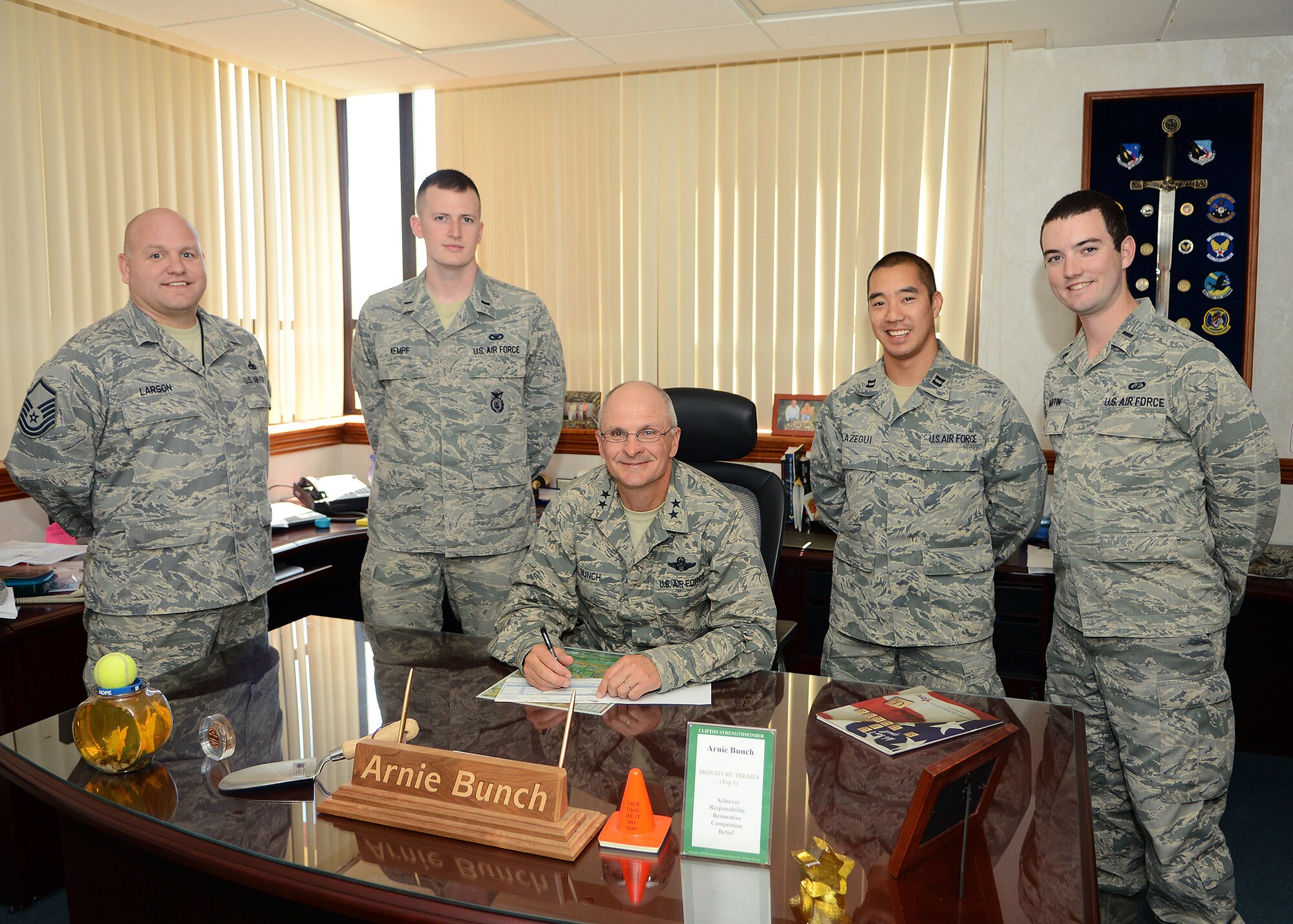 Maj. Gen. Arnold Bunch Jr. (center), Air Force Test Center commander, signed his Combined Federal Campaign pledge form among CFC installation representatives prior to the CFC kick off which occurred Oct. 8. This year's campaign runs till Nov. 22. (U.S. Air Force photo by Jet Fabara)