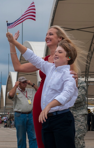 Kathy and Christopher Haworth, wife and son of U.S. Air Force Lt. Col. David Haworth, 74th Fighter Squadron commander, wave as A-10C Thunderbolt II aircraft return home from deployment on Moody Air Force Base, Ga., Oct. 8, 2013. Airmen of the 74th FS deployed to Bagram Airfield, Afghanistan, where they provided close-air support for service members in theater. (U.S. Air Force photo by Airman 1st Class Alexis Grotz/Released)
