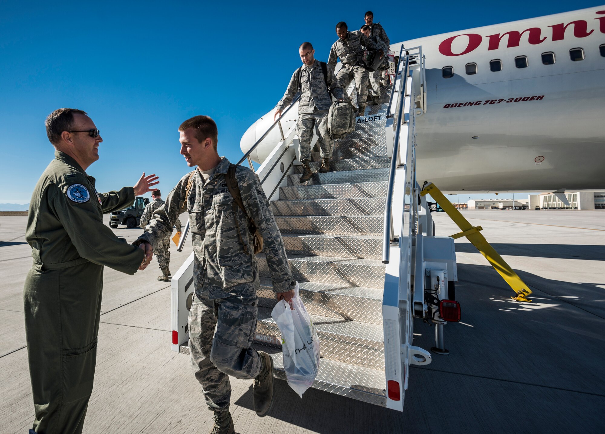 U.S. Air Force Col. Chris Short (left), 366th Fighter Wing commander, shakes hands with the first Airman to disembark an aircraft at Mountain Home Air Force Base, Idaho, Oct. 5, 2013. The Airmen on the plane were returning from a deployment to Southwest Asia. (U.S. Air Force photo by Tech. Sgt. Samuel Morse/RELEASED)