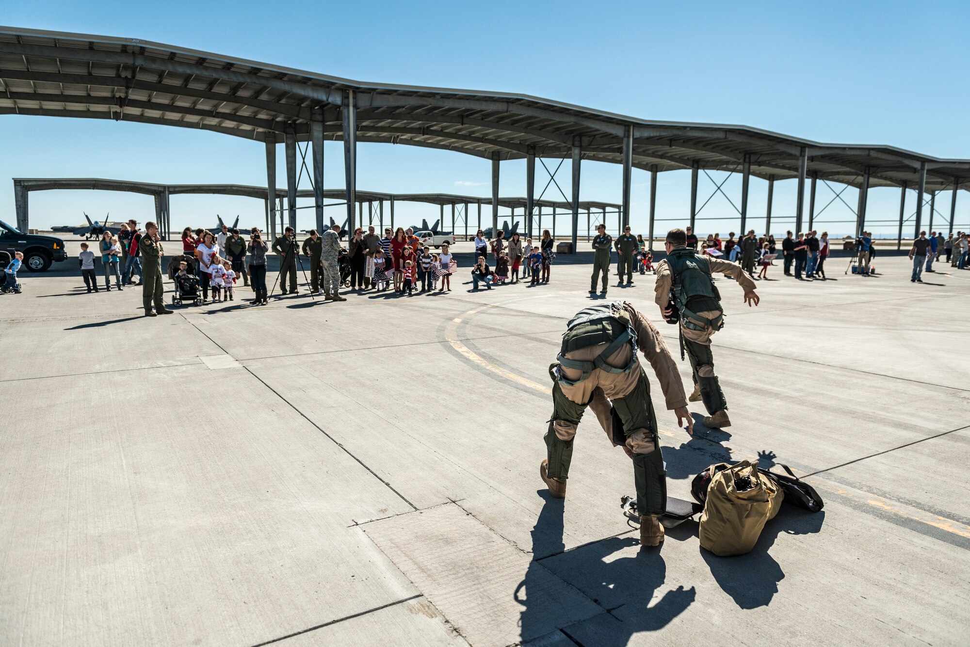 A pilot and weapon systems officer drop their belongings to sprint to their families at Mountain Home Air Force Base, Idaho, Oct. 5, 2013. The pair had just returned from a deployment to Southwest Asia and this was the first time seeing their families. (U.S. Air Force photo by Tech. Sgt. Samuel Morse/RELEASED)