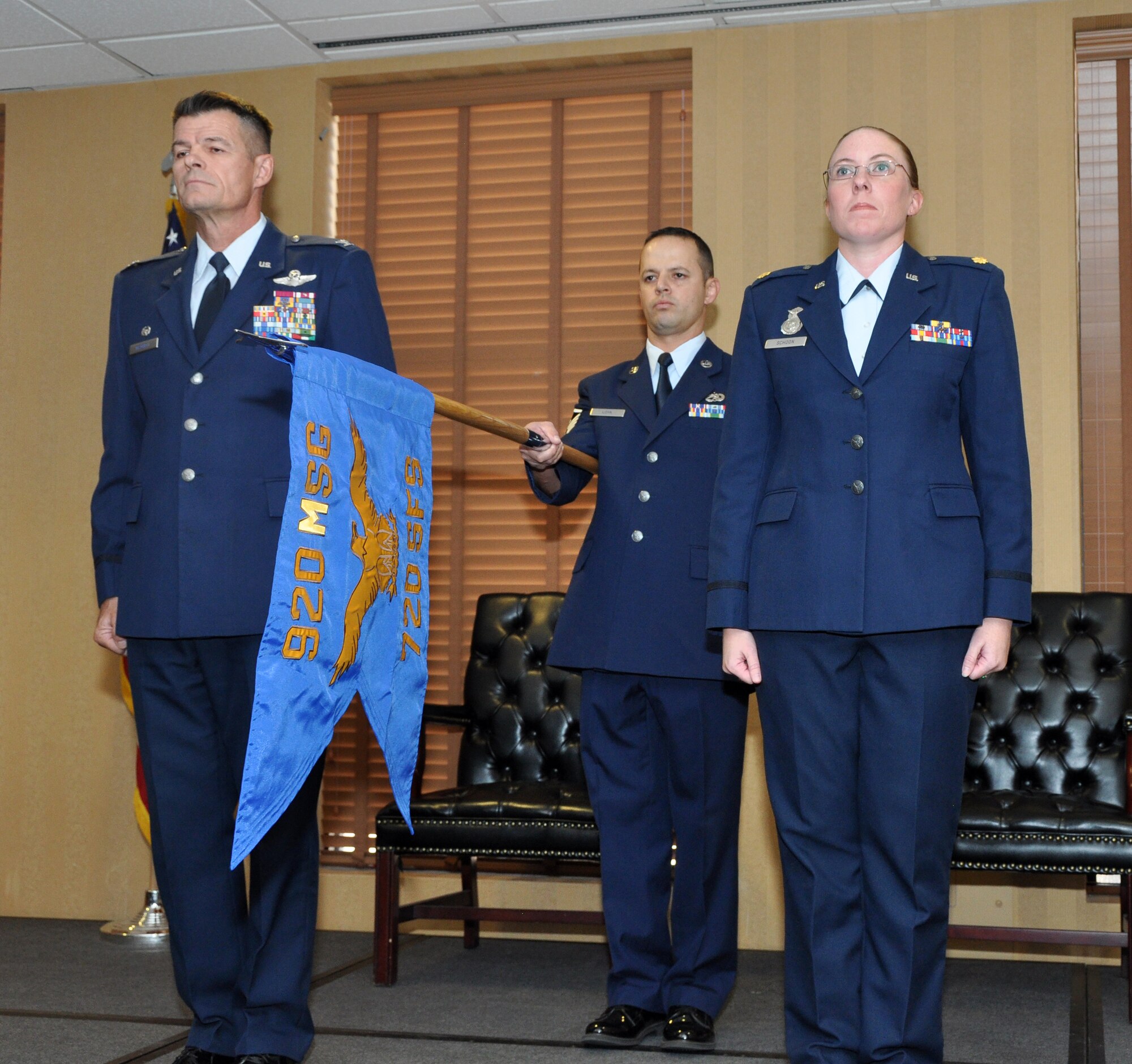 Master Sgt. Arturo Loya, first sergeant for the 720th Security Forces Squadron presents the newest 720th SFS unit flag while Col. Harold Maxwell, commander 943rd Rescue Group and Maj. Vaness Schoon, 720th SFS commander stand at attention during the activation and assumption of command ceremony, Oct. 5. The 720th SFS will fall under the 920th Mission Support Group. (U.S. Air Force Photo/ Staff Sgt. Sarah M. Pullen)