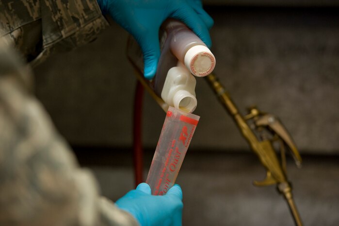 Senior Airman Jason Urquiola, 99th Civil Engineering Squadron pest management journeyman, measures chemicals for insecticide inside the pest management building Oct. 2, 2013, at Nellis Air Force Base, Nev. Insecticide is used to exterminate and prevent ant and roach infestation around the base.  (U.S. Air Force photo by Airman 1st Class Christopher Tam)