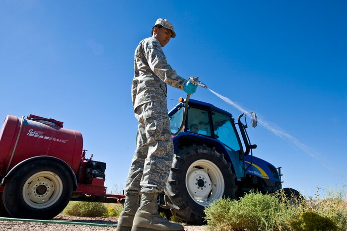 Senior Airman Jason Urquiola, 99th Civil Engineering Squadron pest management journeyman, sprays herbicide outside of the pest management Oct. 2, 2013, at Nellis Air Force Base, Nev. Herbicide is widely on the Nellis AFB flightline to kill weeds growing in between the cracks on the runway. (U.S. Air Force photo by Airman 1st Class Christopher Tam)