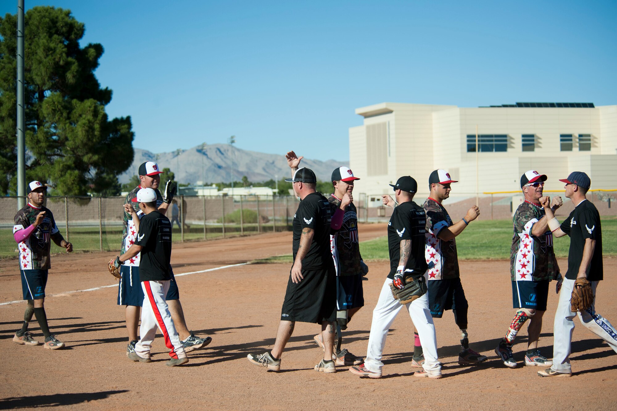 Wounded Warrior Amputee Softball Team members and Airmen from Nellis and Creech Air Force Bases congratulate each other on good games at a baseball field at Freedom Park Oct. 5, 2013, at Nellis AFB, Nev. The WWAST’s mission is to raise awareness through exhibition and celebrity softball games of the sacrifices and resilience of military service members, (U.S. Air Force photo by Airman 1st Class Timothy Young)