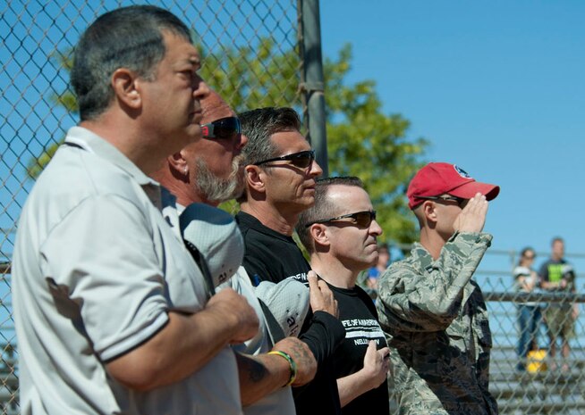 Col. Barry Cornish, 99th  Air Base Wing commander, and Col. Robert Ramsden,  99th ABW vice commander, place their hands over their hearts during the opening ceremonies of a Wounded Warrior softball game at the baseball field at Freedom Park Oct. 5, 2013, at Nellis Air Force Base, Nev. The Wounded Warrior Amputee Softball Team played against Airmen from Nellis and Creech AFBs during a double header. Ramsden started the game by throwing out the first pitch. (U.S. Air Force photo by Airman 1st Class Timothy Young)
