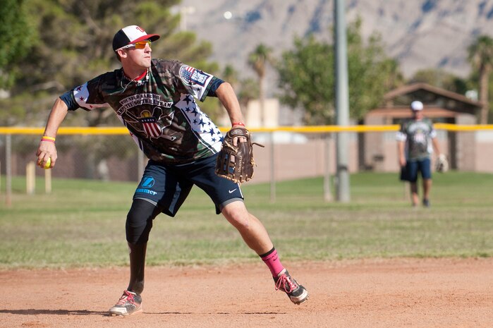 Matthew Kinsey, Wounded Warrior Amputee Softball Team member, prepares to throw a ball to first base during a Wounded Warrior softball game at the baseball field at Freedom Park Oct. 5, 2013, at Nellis Air Force Base, Nev. The WWAST played against Airmen from Nellis and Creech AFBs during a double header. Some WWAST members still serve in the military, and others attend college with the Post-9/11 GI Bill. (U.S. Air Force photo by Staff Sgt. Christopher Hubenthal) (U.S. Air Force photo by Staff Sgt. Christopher Hubenthal)