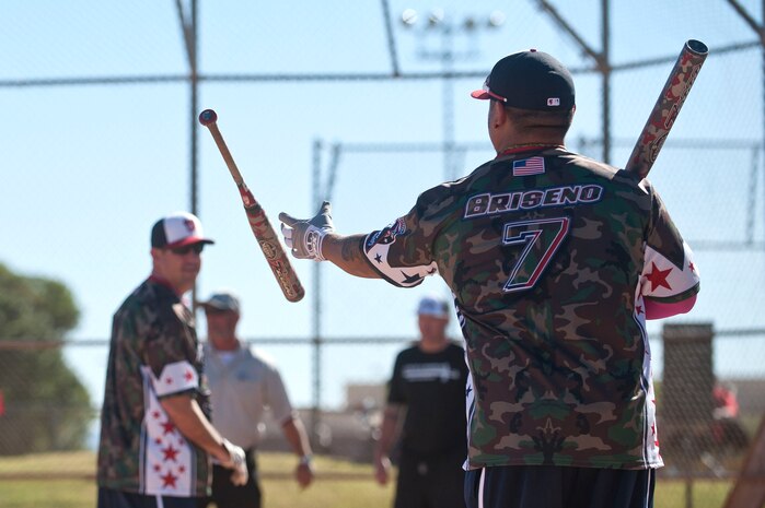 Zachary Briseno, Wounded Warrior Amputee Softball Team member, tosses a softball bat to a teammate during a Wounded Warrior softball game at the baseball field at Freedom Park Oct. 5, 2013.  The WWAST played against Airmen from Nellis and Creech AFBs during a double header. The WWAST roster is comprised of veterans who have undergone an amputation or multiple amputations while serving in the military after 9/11. (U.S. Air Force photo by Staff Sgt. Christopher Hubenthal)