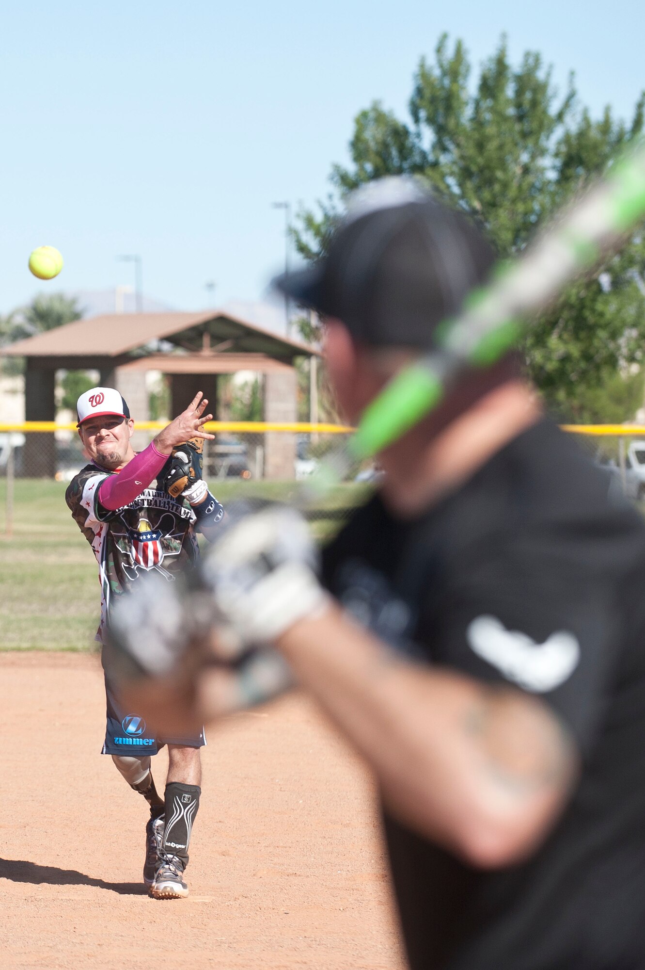Michael Dreyer, Wounded Warrior Amputee Softball Team member, pitches a ball during a Wounded Warrior softball game at the baseball field at Freedom Park Oct. 5, 2013, at Nellis Air Force Base, Nev. Airmen from Nellis and Creech AFBs defeated the Wounded Warrior Amputee Softball Team 15-10 and 25-11 during a double header. While some WWAST members still serve in the military, others attend college with the Post-9/11 GI Bill. (U.S. Air Force photo by Staff Sgt. Christopher Hubenthal)