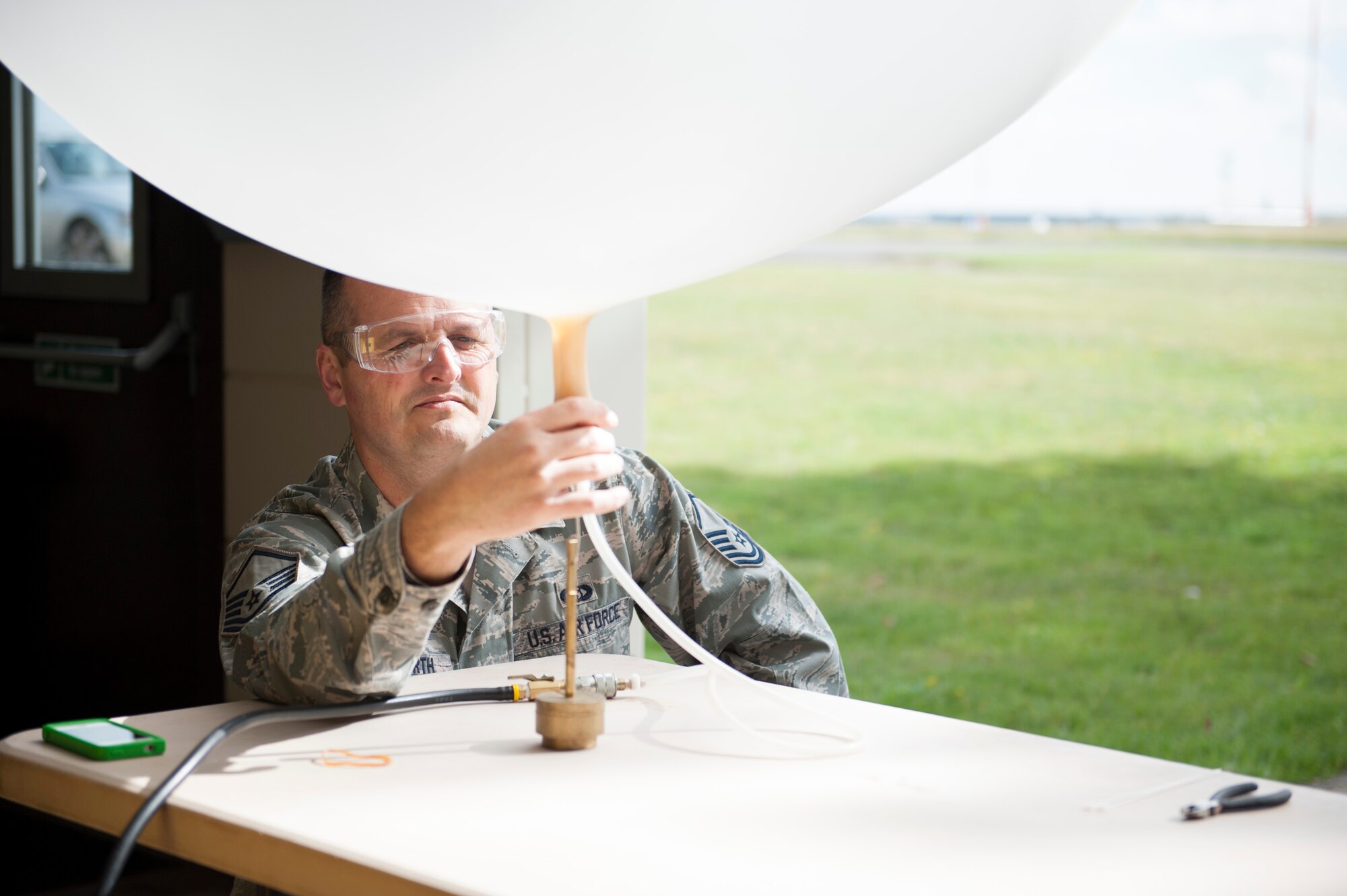 Master Sgt. Phillip Whitworth, 352nd Special Operation Support Squadron Weather Flight chief, fills a weather balloon at RAF Mildenhall, England, Sept. 18, 2013. The 352nd SOSS Weather Flight provides accurate and timely weather information in support of the 352nd Special Operations Group. (U.S. Air Force photo by Staff Sgt. Stephen Linch)