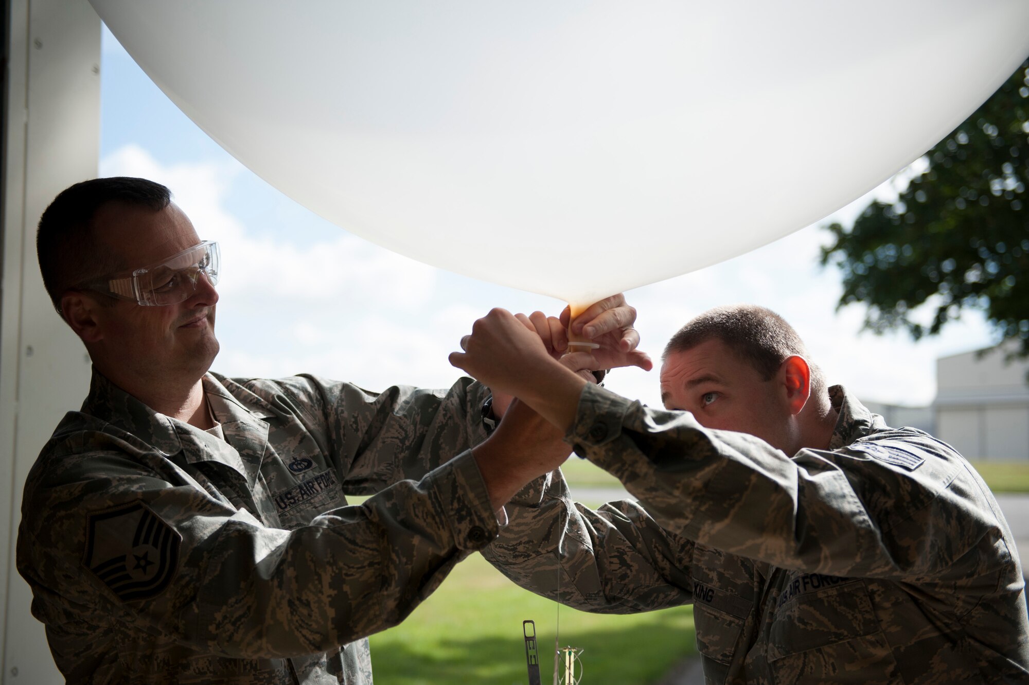 Master Sgt. Phillip Whitworth (left), 352nd Special Operation Support Squadron Weather Flight chief, and Staff Sgt. Michael King, 352nd SOSS Weather Flight forecaster, prepare a weather balloon to be launched at RAF Mildenhall, England, Sept. 18, 2013. The 352nd SOSS Weather Flight uses weather balloons to gather atmospheric data such as temperature, humidity and wind speed. (U.S. Air Force photo by Staff Sgt. Stephen Linch)
