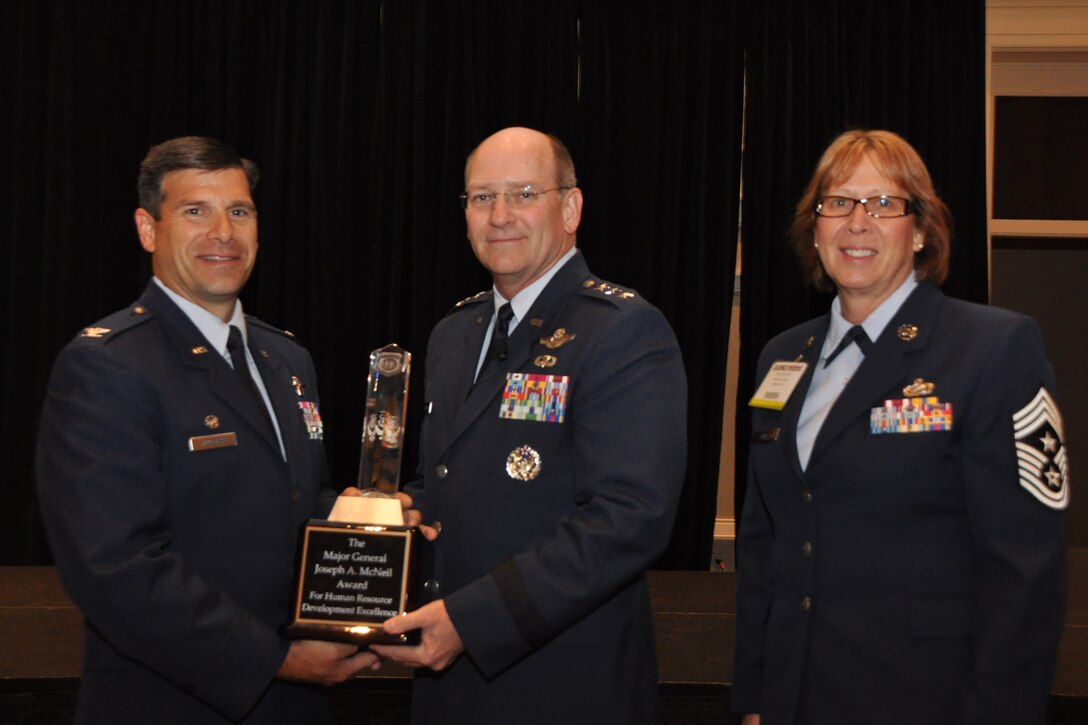 Commander of the Air Force Reserve Command, Lt. Gen. James "JJ" Jackson, presents the Major General Joseph A. McNeil Award (small wing category) for Human Resource Development Excellence, to the commander of the 932nd Airlift Wing, Col. Albert Lupenski (at left,) and the highest ranking enlisted member of the unit, Command Chief Master Sgt. Vicky Kuntz (right).  (U.S. Air Force photo/SSgt. Katie Spencer)  