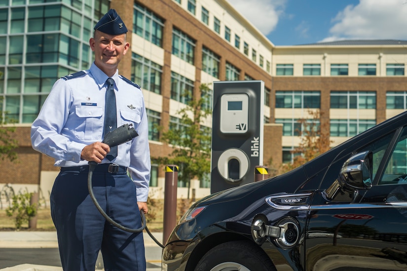 Col. William Knight, 11th Wing commander, holds a battery-charging device for a plug-in electric vehicle at Joint Base Andrews, Md. Air Force officials selected Joint Bases Andrews and McGuire-Dix-Lakehurst, N.J., and Los Angeles Air Force Base, Calif., to become the initial federal enclave to replace their entire passenger vehicle fleet with electric models. JBA’s battery-charged versions will consist of cargo/utility-type vehicles such as pickup and flatbed trucks, as well as panel vans. (U.S. Air Force photo/Master Sgt. Jeffrey Allen) 